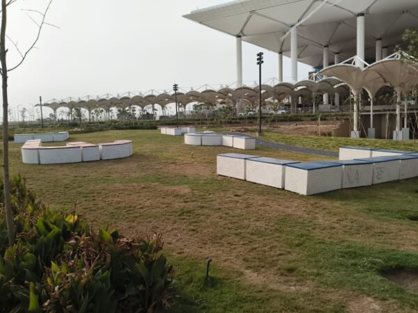 Eco-friendly seating modules crafted from recycled polycarbonate waste at the arrival zone of Noida International Airport.